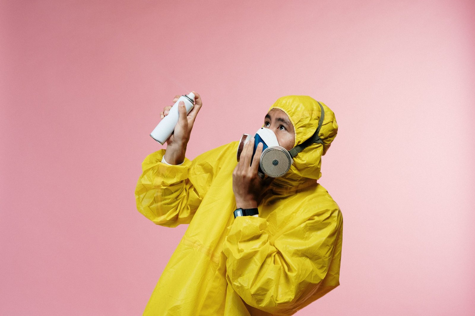Homme en combinaison et masque avec un spray