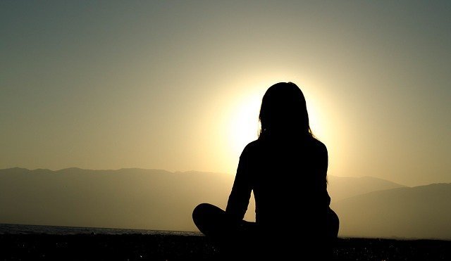 Femme assise face à la montagne