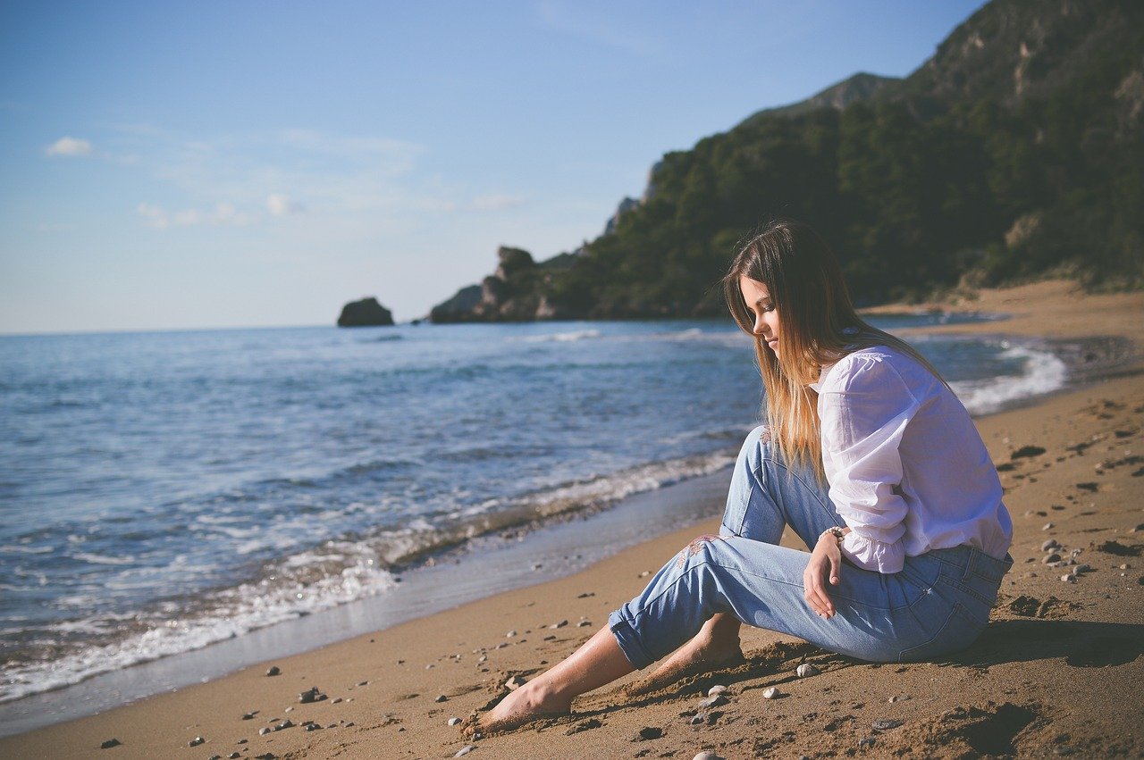 Femme seule sur la plage avec ses pensées
