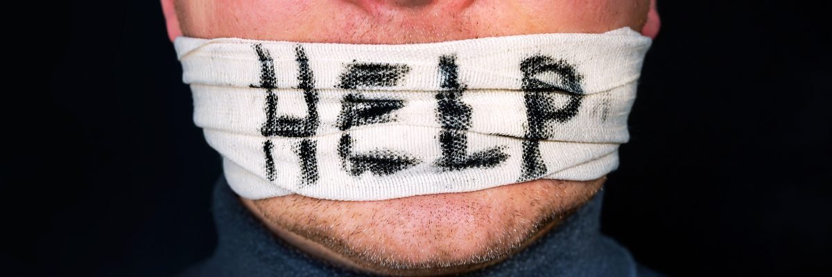isage d’une personne avec la bouche scotchée par un sparadrap sur lequel est écrit « HELP », symbolisant le silence et la détresse face aux problèmes de santé mentale au travail.