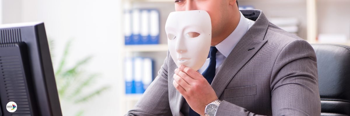 Personne au bureau tenant un masque devant son visage
