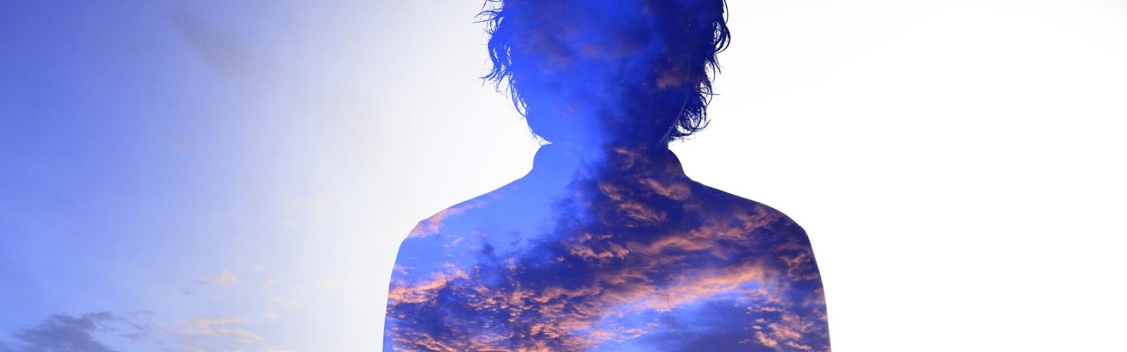 Silhouette se fondant dans le ciel et les nuages, symbolisant le fait de s’oublier pour être aimé, dans une atmosphère lumineuse et légère.