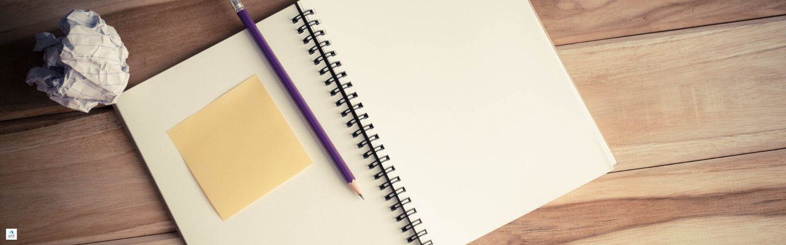 Vue d’un carnet ouvert sur une table en bois, avec un crayon violet et un post-it, symbolisant la réflexion et l’organisation pour construire une confiance durable.