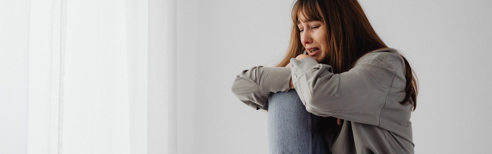 Femme assise, repliée sur elle-même, exprimant un sentiment d’insécurité et de vulnérabilité intérieure