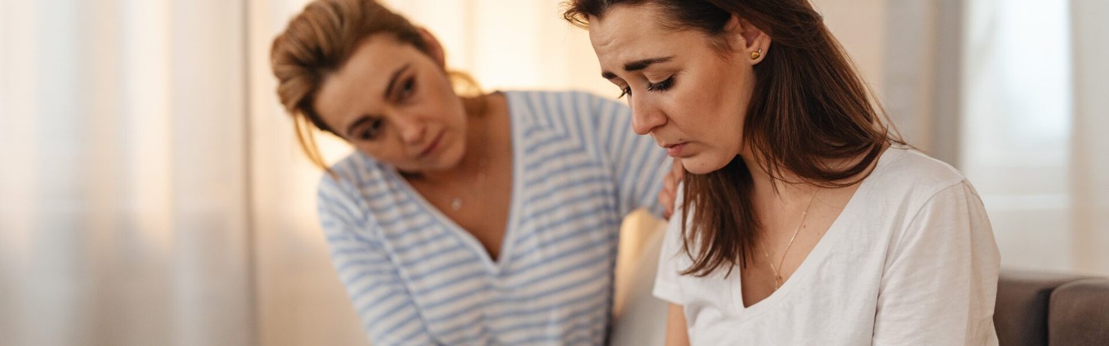 Deux femmes en intérieur dans une scène de soutien émotionnel, illustrant le fait que comprendre n’est pas tout accepter dans les relations humaines.