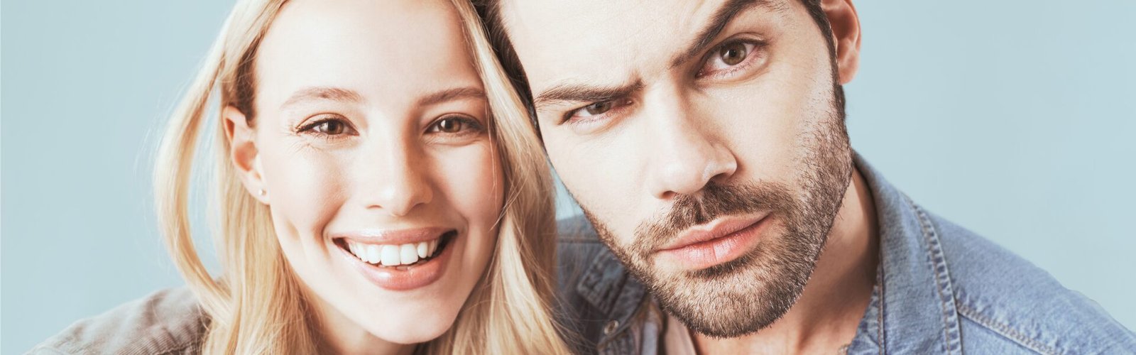 Couple, femme souriante et homme au regard perplexe